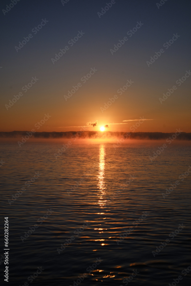 暖かい太陽の光を浴びる早朝の海