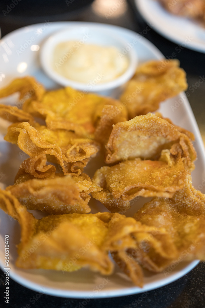 Fried wonton with sauce on a white dish. Close up Fried wonton with sauce on a white dish. Close up
