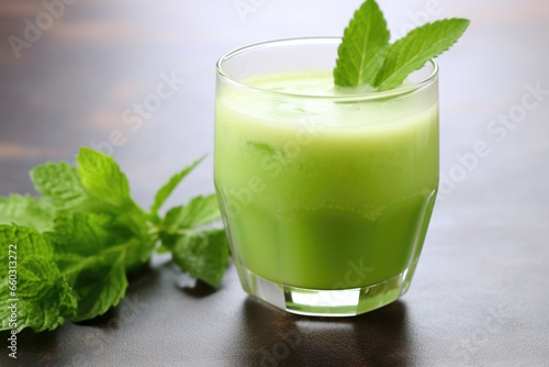 glass of celery juice with celery leaves as garnish