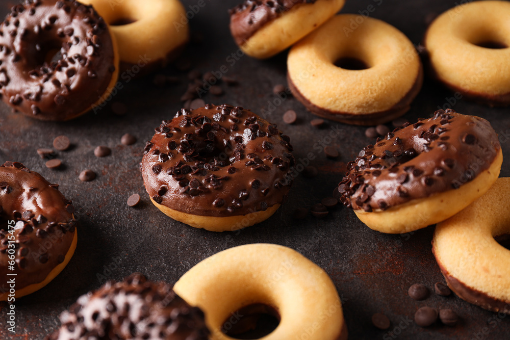Chocolate donuts and chocolate chips on dark gray background, close up