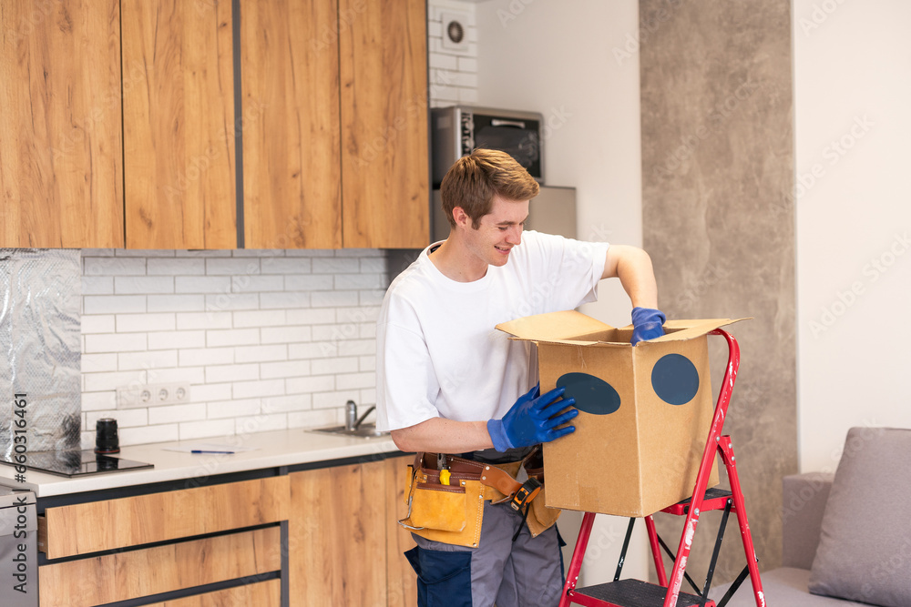 Young happy delivery man unloading boxes.