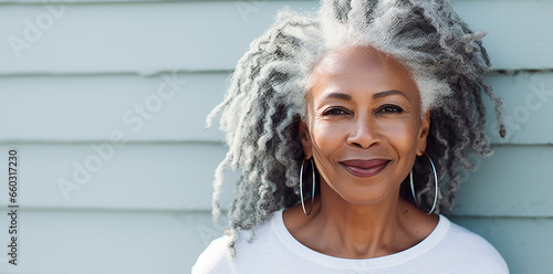  portrait of a beautiful elderly black  woman with long white grey  hair, dressed white and  outdoor background, posing and looking on camera photo