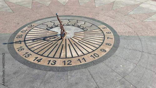 Close-up view of horizontal sundial on city square in a sunny summer day. Five o'clock. Evening high tea time. Soft focus. Slow motion video. Time theme.