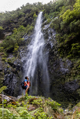 Person located at the foot of a waterfall and looking towards it. Route that runs from the road between the levada of Caldeirão Verde and Caldeirão do Inferno