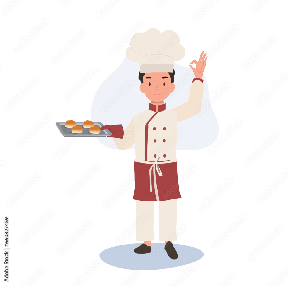 Young Chef Showing OK Sign. Happy Chef Doing OK Hand Sign and holding fresh baked bun on tray in other hand Young Chef Showing OK Sign. Happy Chef Doing OK Hand Sign and holding fresh baked bun on tray in other hand