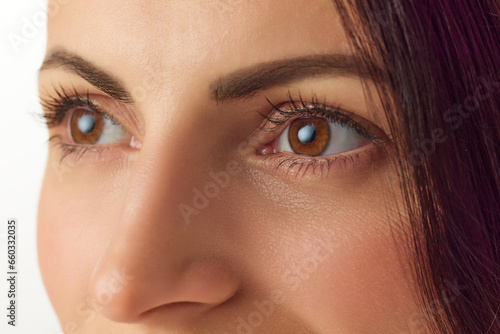 Extreme close-up cropped photo of brunette good-looking woman face, eyes, nose. Beauty procedures. Skin care cosmetic treatment.