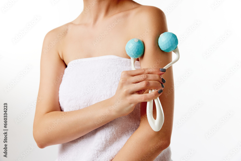 Cropped photo of girl, woman and perfect skin doing body procedures with massage roller over white color studio background Cropped photo of girl, woman and perfect skin doing body procedures with massage roller over white color studio background