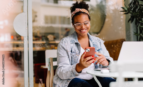 Female freelancer using smartphone in a cafe