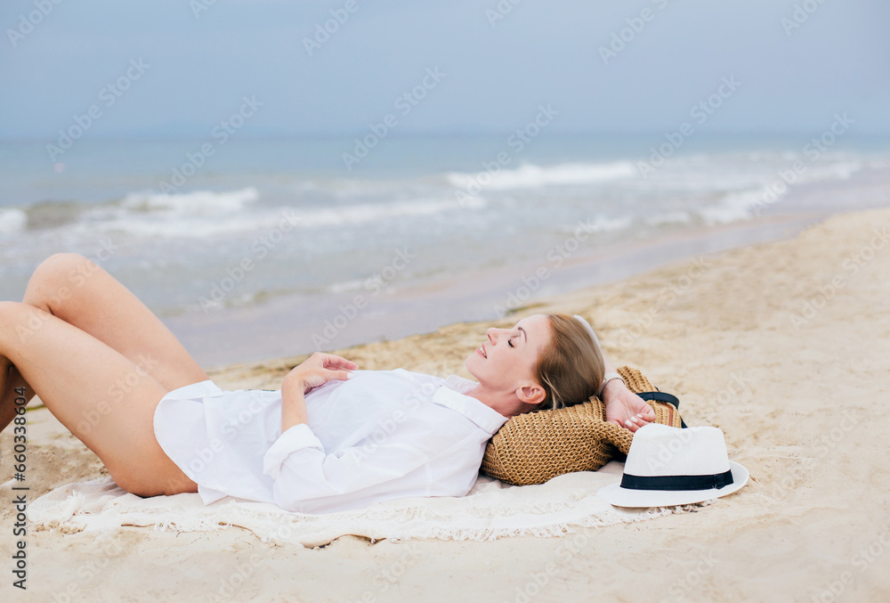 woman lies on the beach on the sand at the seashore