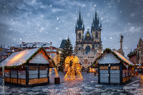 Beautiful winter view of the old town square of Prague, Czech Republic, with a christmas market and the famous Tyn Church with snow