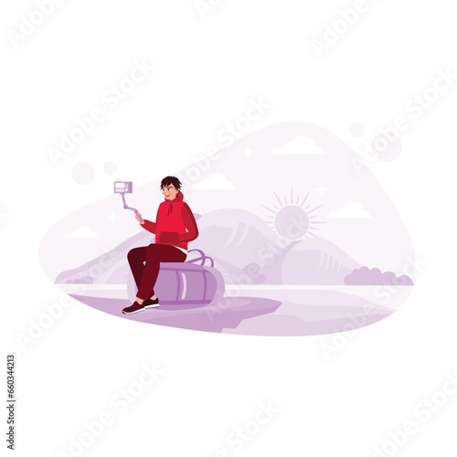 A man sitting on a suitcase takes a travel video on vacation with a view of the clear sky. Travel blogger. Content Creator concept. Trend Modern vector flat illustration