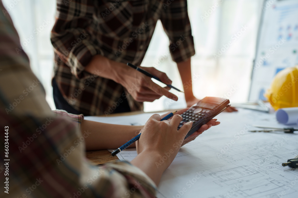 Fototapeta premium multi ethnic engineer brainstorming and measuring for cost estimating on blueprint and floor plan drawings about design architectural and engineering for houses and buildings