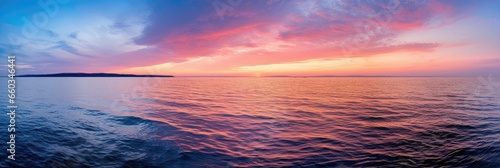 Sunset over calm sea with sky reflection
