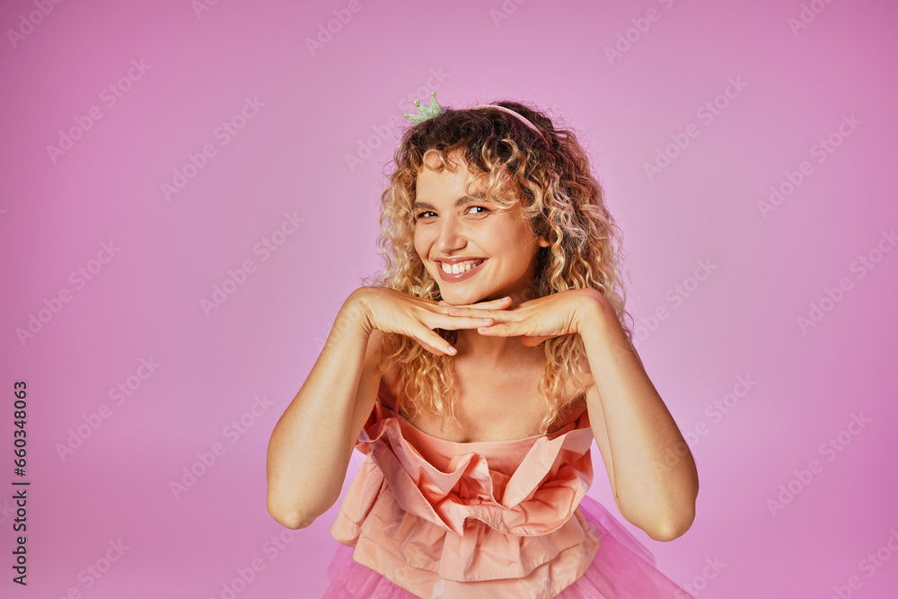 attractive blonde woman in tooth fairy costume looking happily at camera with hand under chin attractive blonde woman in tooth fairy costume looking happily at camera with hand under chin