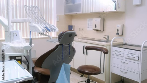 Empty modern light dentist office in clinic with equipment, computer, professional dental chair and drilling machine. Dental clinic interior