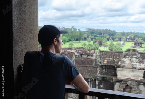 Unrecognizable European Tourist Contemplating The Jungle And the Ruins Of Angkor Wat