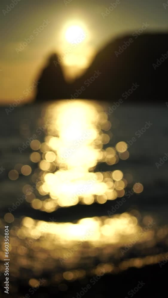 Abstract nature summer or spring ocean sea background. Small waves on water surface in motion blur with bokeh lights from sunrise. Holiday, vacation and recreational background concept. Vertical video Abstract nature summer or spring ocean sea background. Small waves on water surface in motion blur with bokeh lights from sunrise. Holiday, vacation and recreational background concept. Vertical video
