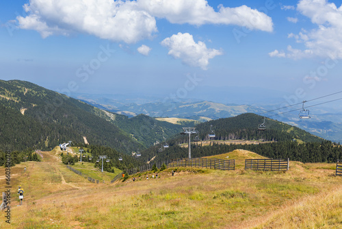 Chairlift on mountain landscape at summer day.