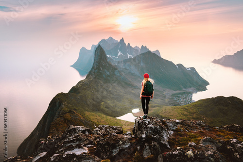 Traveler woman hiking solo in mountains of Norway outdoor activity travel summer vacations healthy lifestyle girl tourist enjoying sunset view on summit exploring Senja island photo