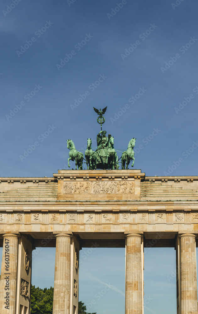 view of majestic historical gate in city with copper statues of horses and woman riding carriage branderburg  