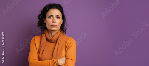 Serious Brunette Woman in Brown Outfit on Purple Background