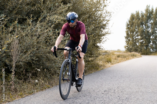 Detail shot of the legs of a cyclist riding a bike in the countryside.