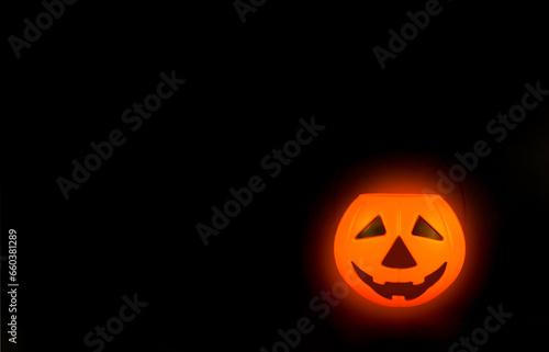 Decorative glowing pumpkin on a black background, copy space