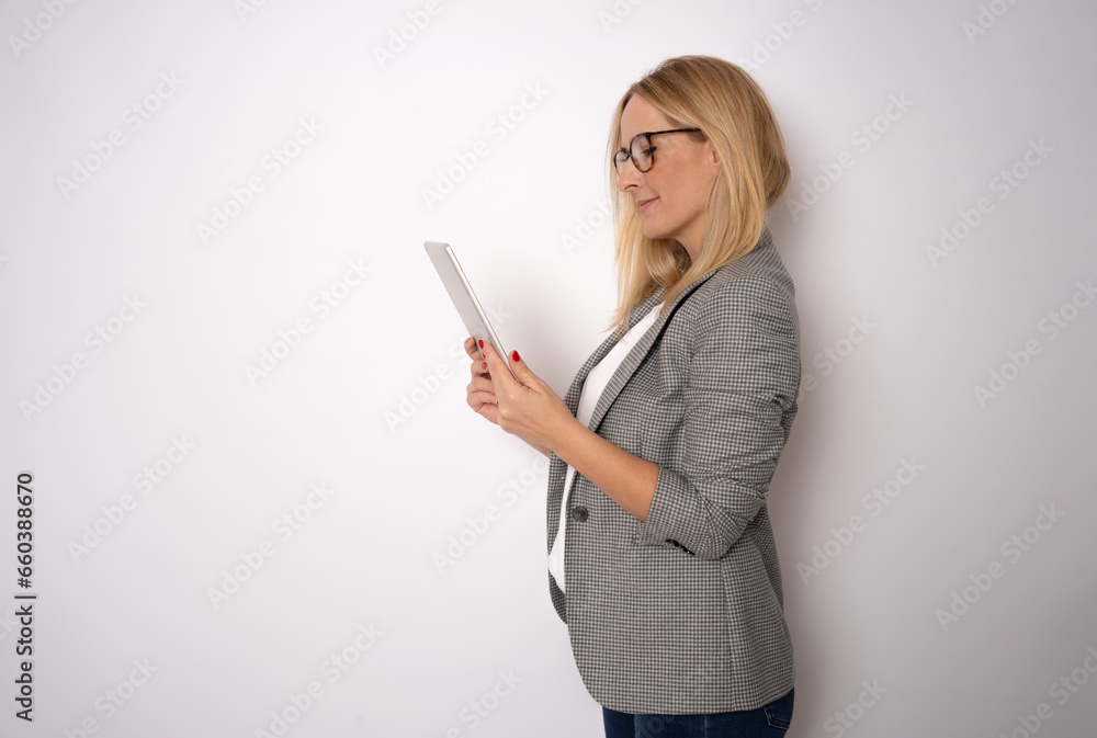 Portrait of happy young blonde business woman using tablet isolated against white background. Smiling pretty girl holding a digital tablet computer. Modern technologies and business Portrait of happy young blonde business woman using tablet isolated against white background. Smiling pretty girl holding a digital tablet computer. Modern technologies and business