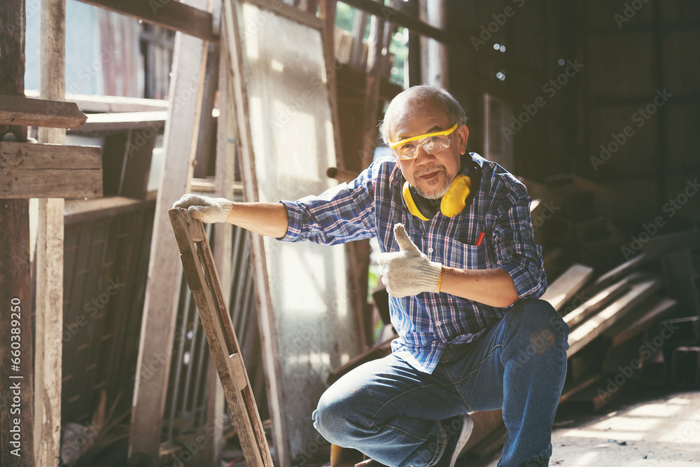 Senior Asian male carpenter working and inspecting quality of wood frame at furniture workshop. Asian male joiner working at woodwork workshop Senior Asian male carpenter working and inspecting quality of wood frame at furniture workshop. Asian male joiner working at woodwork workshop