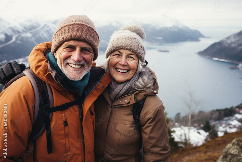 Senior couple while winter hiking, filled with wonder at the beauty of nature during their active retirement Senior couple while winter hiking, filled with wonder at the beauty of nature during their active retirement