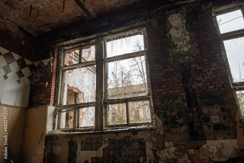 Interior of shabby room of desolate building with crumbling brick walls and arches