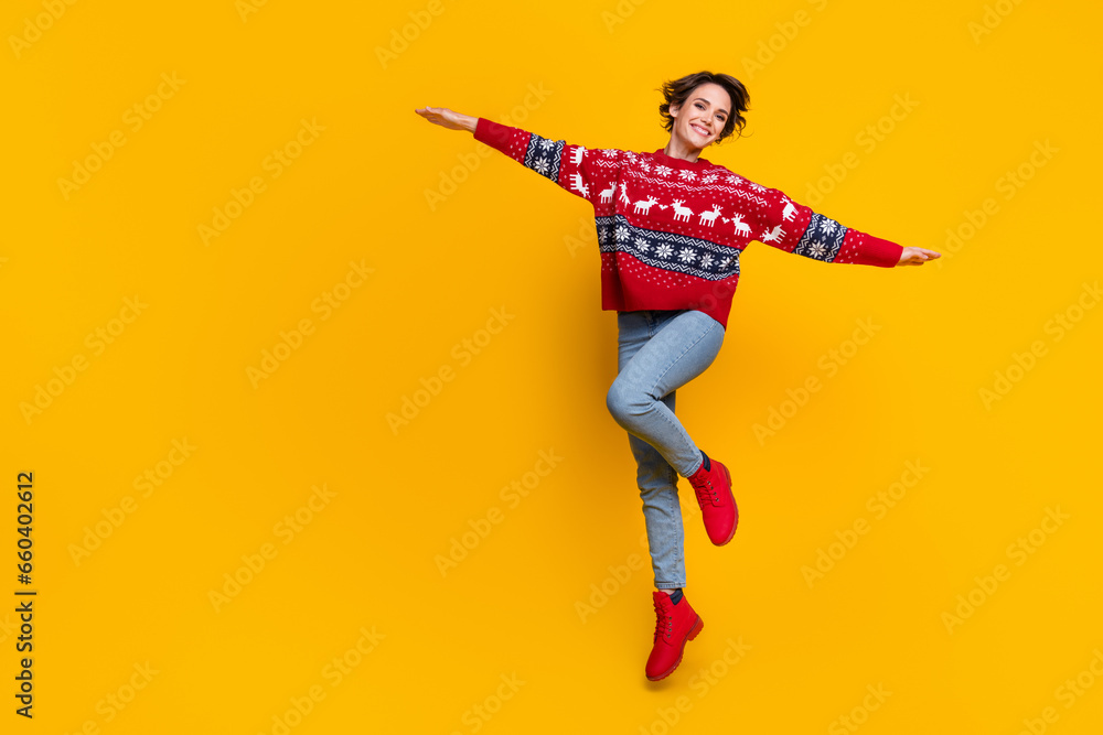 Full length photo of dreamy optimistic girl dressed red jumper flying holding palms like wings isolated on yellow color background - obrazy, fototapety, plakaty 