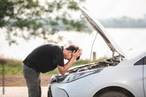 Canvas Print A stressed young man has a problem with his car breaking down