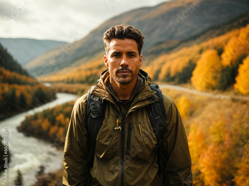 young man in a hiking in nature along a small river with a jacket and a hiking backpack