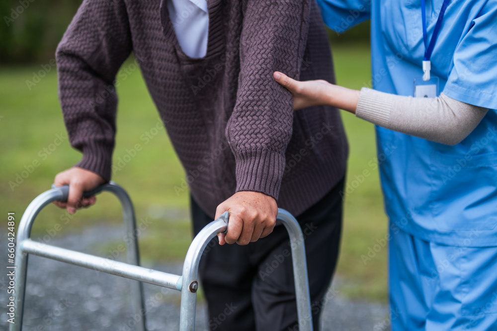 Physical therapist caregiver talking to senior man using a walker at home. concept home healthcare nurse, physical therapy with senior adult at home