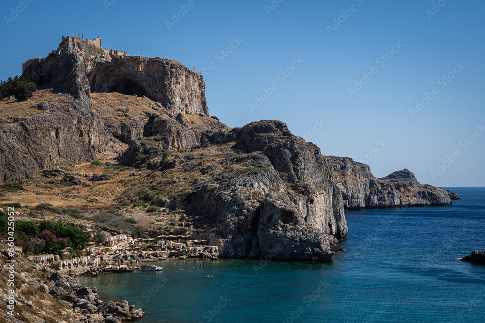 Enchanting Bay in Lindos, Rhodes: A serene Mediterranean retreat where moored boats meet the captivating turquoise embrace of the sea.