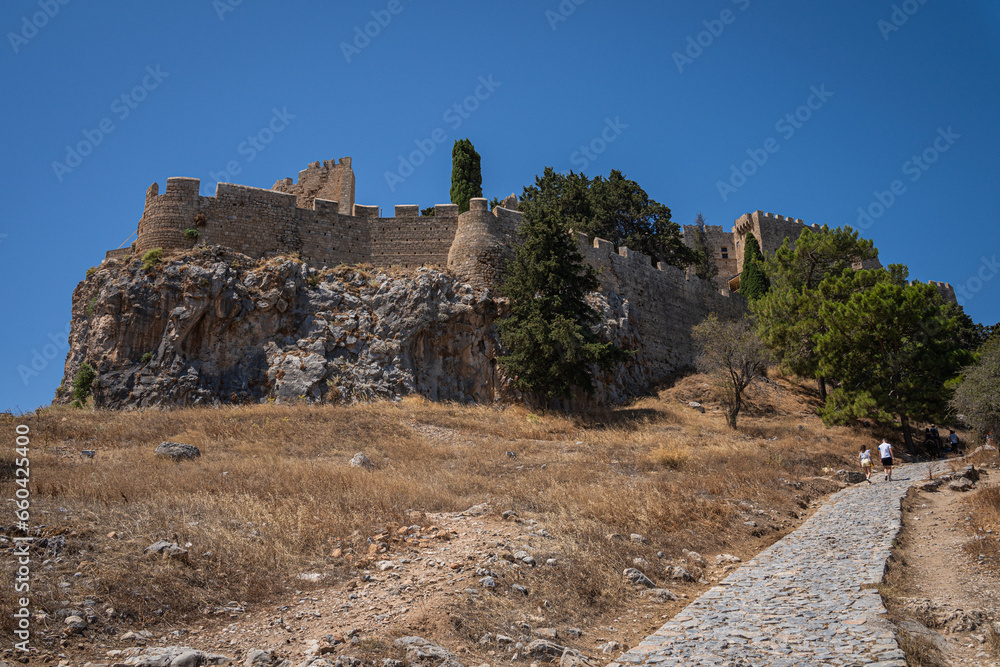 The Ascent to the Acropolis of Lindos: A path steeped in history, revealing the splendors of Rhodes Island and the shimmering Mediterranean with every step.