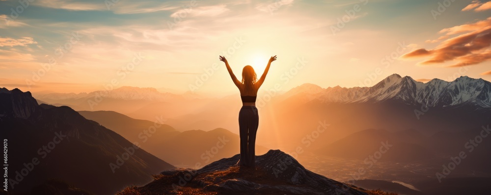A person celebrating on top of a mountain