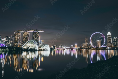 Nighttime view of the Marina Bay skyline in Singapore, with its reflections in the tranquil water