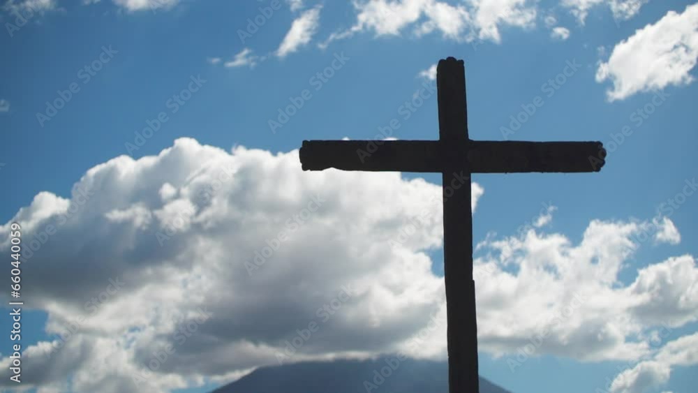 Silhouette view of a big wooden cross against blue cloudy sky at sunset Silhouette view of a big wooden cross against blue cloudy sky at sunset