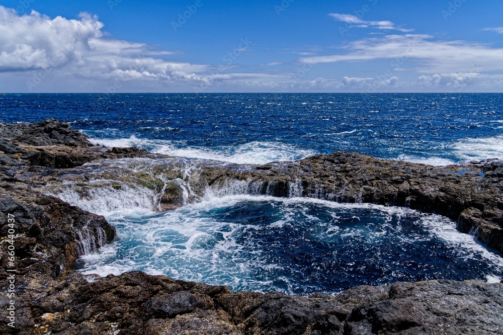 Scenic view of a rocky shoreline in a tranquil blue seascape Scenic view of a rocky shoreline in a tranquil blue seascape