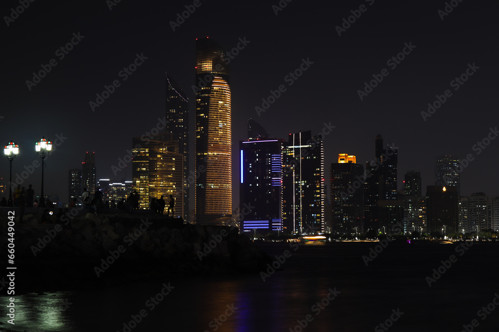 Obraz premium Colorful Abu dhabi city skyline at night and rise of full moon