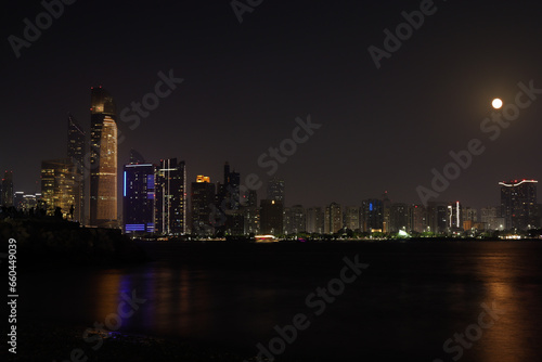 Colorful Abu dhabi city skyline at night and rise of full moon © Baskaran