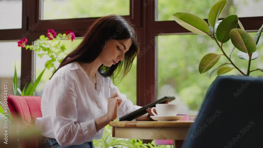 Pretty Brunette Woman Working Online With Graphic Tablet In Cafe, Drawing Digital Picture, Portrait Pretty Brunette Woman Working Online With Graphic Tablet In Cafe, Drawing Digital Picture, Portrait