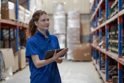 Distribution warehouse worker using digital tablet checking inventory storage on shelf. Female inventory supervisor or logistic engineer working at storage room in storehouse. Goods supply management
