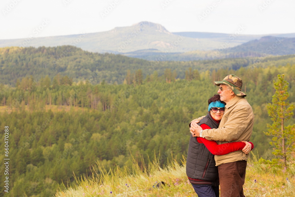 beautiful mature couple on the slope of the mountain of the southern Urals on a summer day