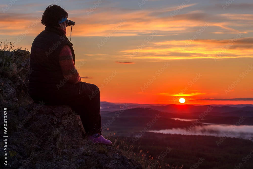 a beautiful mature woman meets the dawn on the Nurali ridge in the southern Urals in Bashkortostan