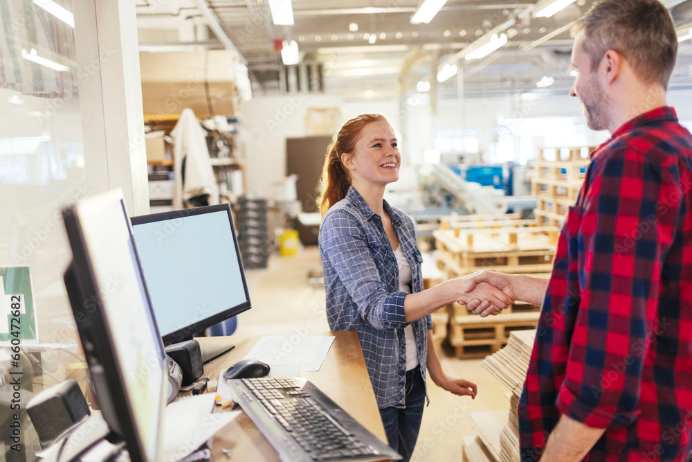 Two diverse coworkers handshaking each other at the warehouse Two diverse coworkers handshaking each other at the warehouse