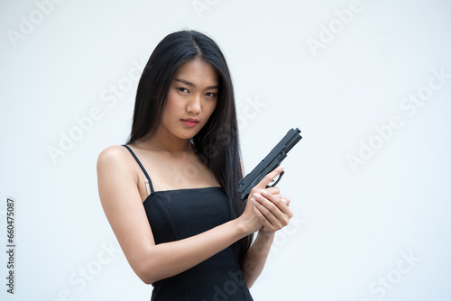 Fototapeta Sexy beauty young woman in black camisole posing with gun on white background