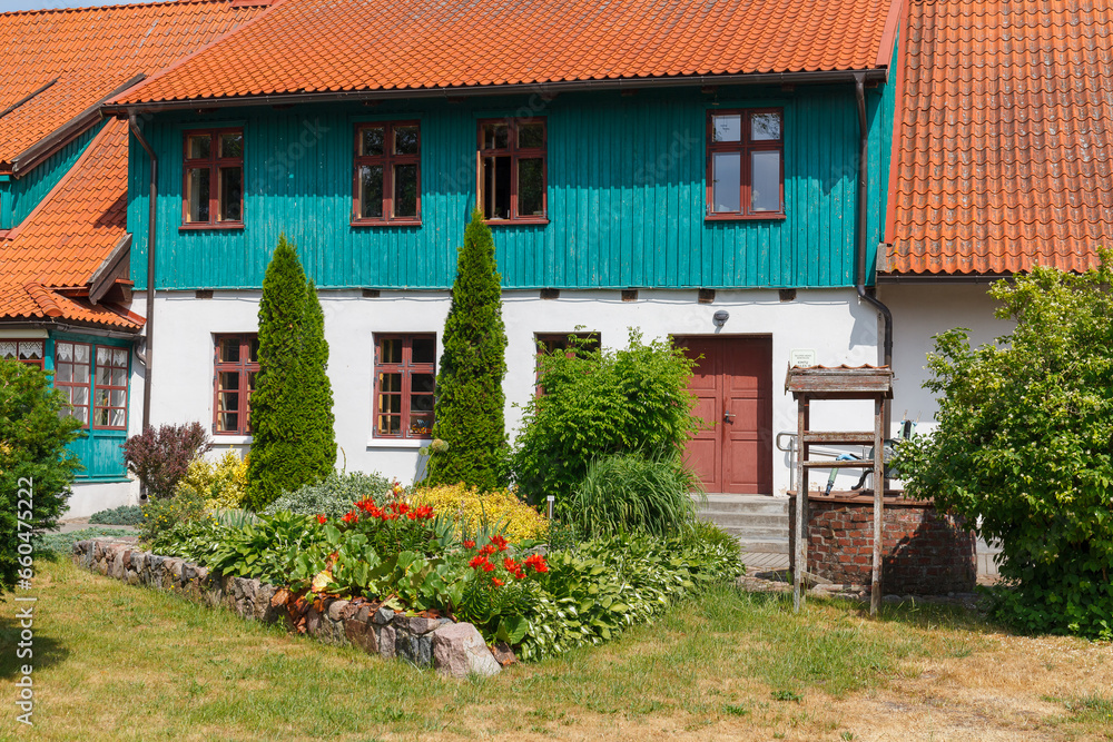 Colorful rural house with red roof in Lithianian countryside